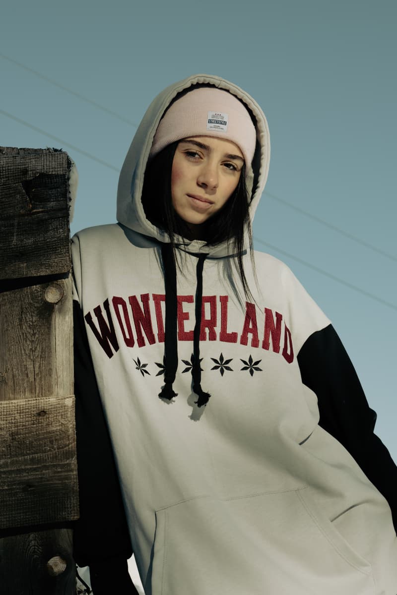 Žena u bordo varijanti Wonderland duksa LONG uz drvenu ogradu na snegu