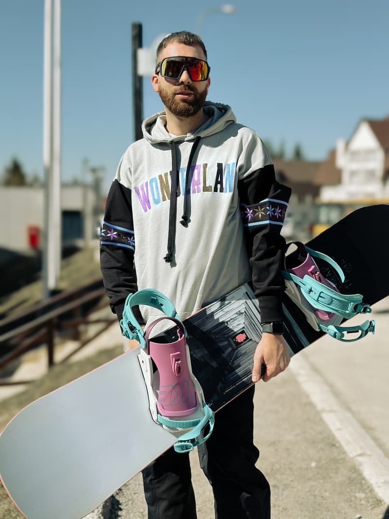 Muškarac u šarenoj varijanti Wonderland duksa LONG sa snowboardom