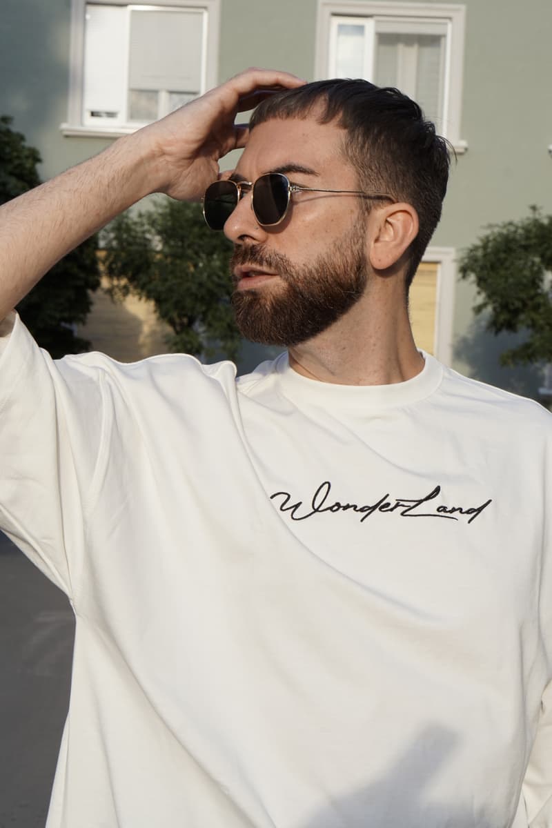 Muškarac u beloj Wonderland oversize majici, krupan kadar