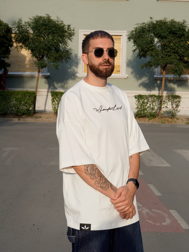 Muškarac u beloj Wonderland oversize majici, prikaz celog kroja